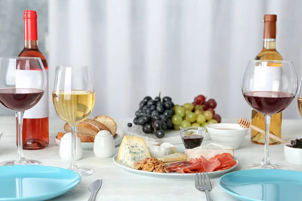 Wine and snacks served for dinner on table at home