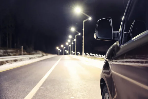 Modern car on asphalt road at night