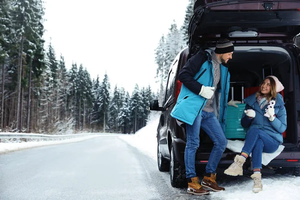 Пара Рядом Открытой Машиной Багажник Полный Багажа Снежной Дороге Место — стоковое фото