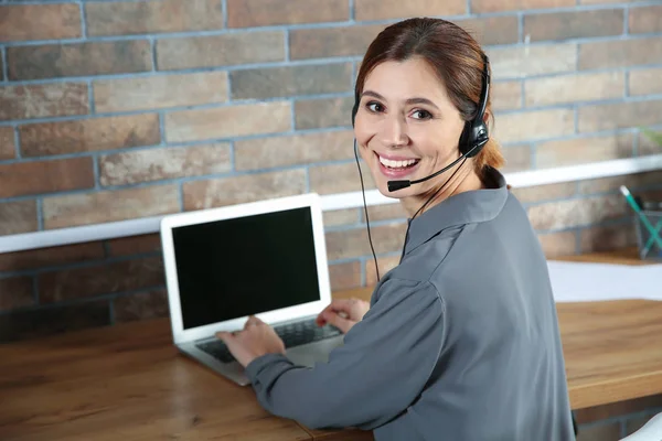 Female technical support operator with headset at workplace