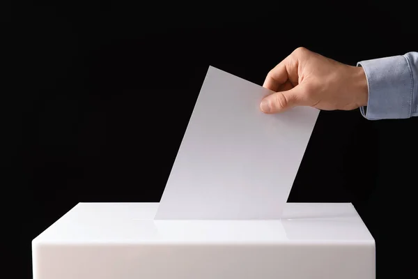 Homem Colocando Seu Voto Urna Fundo Preto Close — Fotografia de Stock