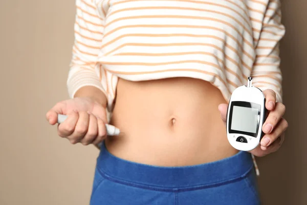妇女与胰岛素注射器和血糖仪在颜色背景 特写镜头 糖尿病 — 图库照片