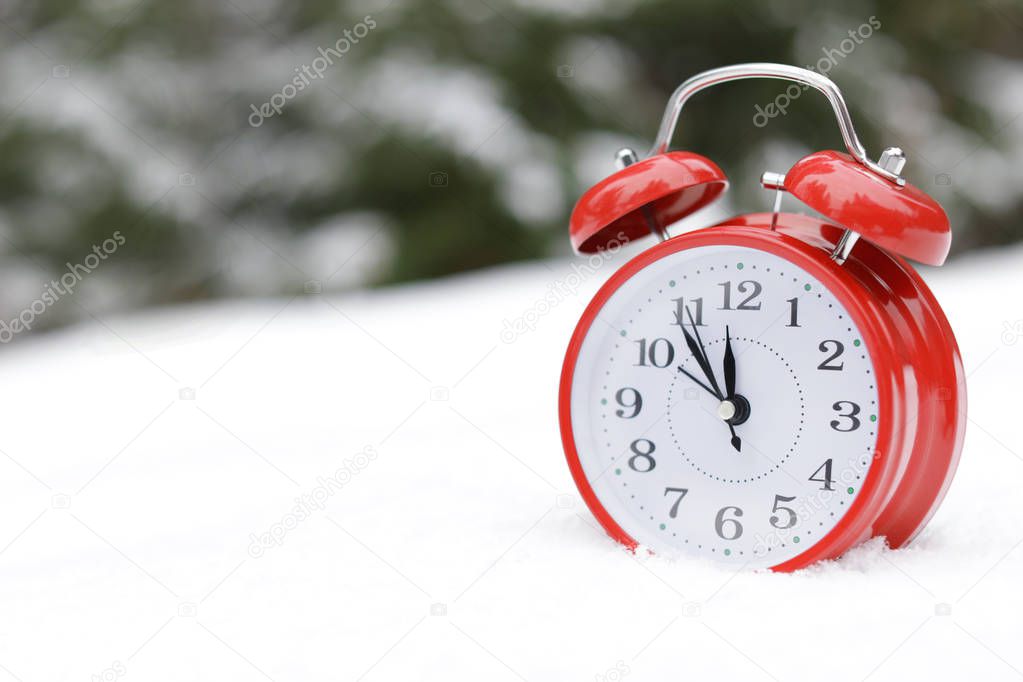 Red alarm clock on white snow outdoors. Space for text
