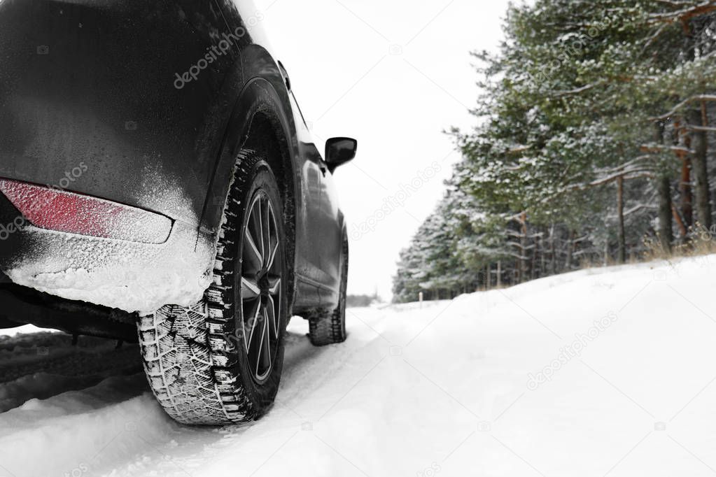 Snowy country road with car on winter day. Space for text