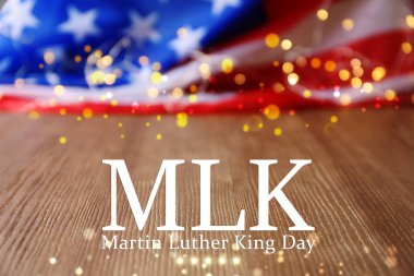 ABD ve ahşap masa üzerinde parlayan ışıklar bulanık bayrağı. Martin Luther King günü için poster