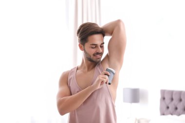 Yatak odasında deodorant uygulamak yakışıklı genç