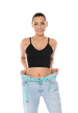 Beyaz arka plan kasette ölçme ile büyük boy kot ince kadın. Kilo kaybı