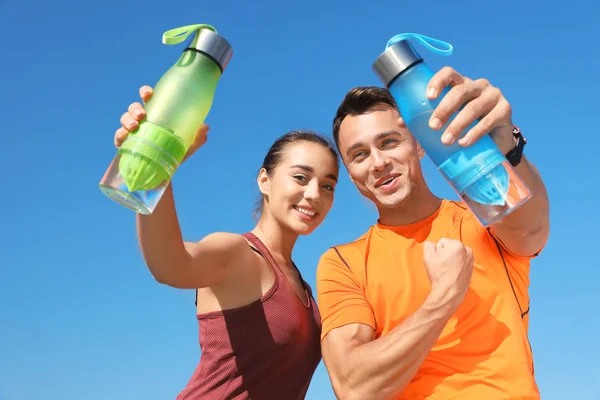 Jeune Couple Sportif Tenant Des Bouteilles Eau Contre Ciel Bleu — Photo