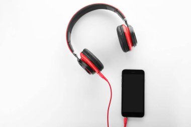 Smartphone ile kulaklıklar beyaz arka plan üzerinde üst görünüm. Metin için yer