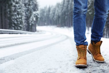 Man walking outdoors on snowy winter day. Space for text clipart