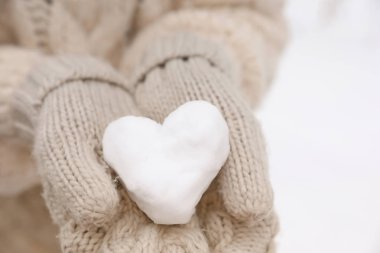 Kar, closeup görünümü yapılan kalp tutan kadın