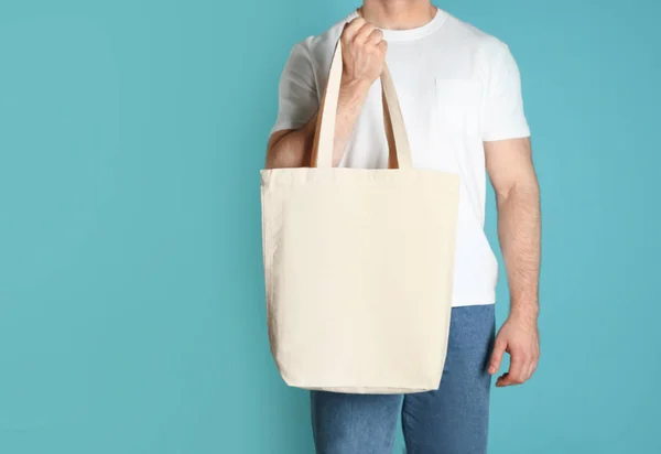 Mann Mit Baumwolleinkaufstasche Auf Farbigem Hintergrund Design Attrappe — Stockfoto