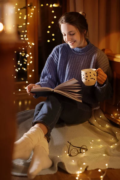 Mujer Con Taza Libro Lectura Bebidas Calientes Casa Noche Invierno — Foto de Stock