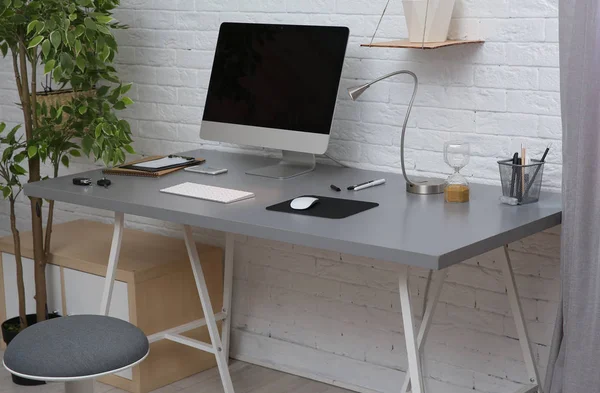 Interior of comfortable work place with computer on table at home