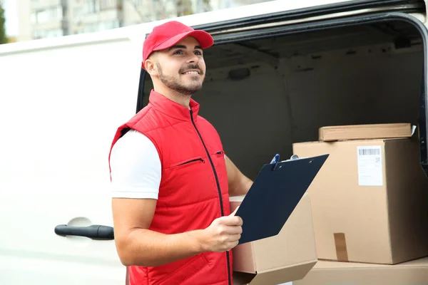 Young Courier Holding Clipboard Parcel Van Outdoors — Φωτογραφία Αρχείου