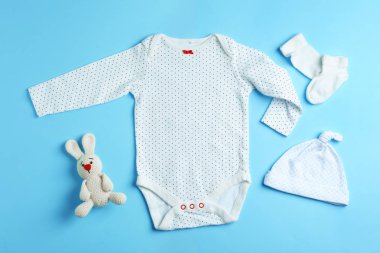 Düz yatıyordu kompozisyon ile şirin kıyafetleri renk arka plan üzerinde. Bebek Aksesuarları