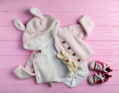 Ahşap arka plan üzerinde şirin giysiler ile düz yatıyordu kompozisyon. Bebek Aksesuarları