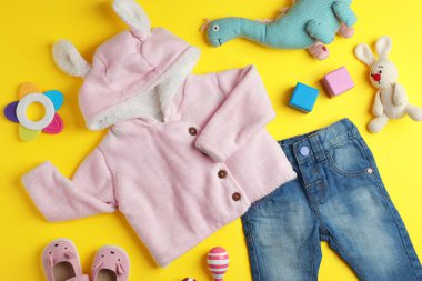 Düz yatıyordu kompozisyon ile şirin kıyafetleri renk arka plan üzerinde. Bebek Aksesuarları