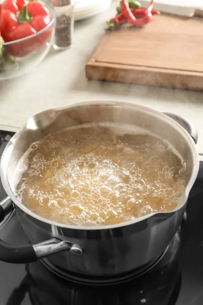 Cooking pasta in pot on electric stove