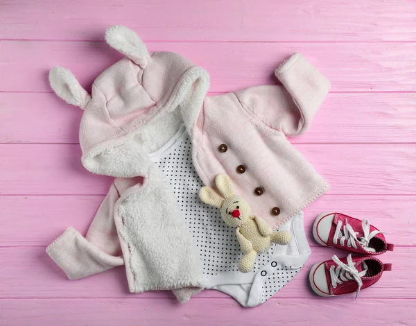 Flat lay composition with cute clothes on wooden background. Baby accessories