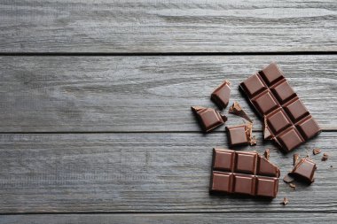 Lezzetli çikolata, düz ahşap arka plan üzerinde yatıyordu. Metin için yer