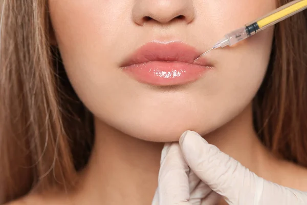 Young woman getting lips injection, closeup. Cosmetic surgery