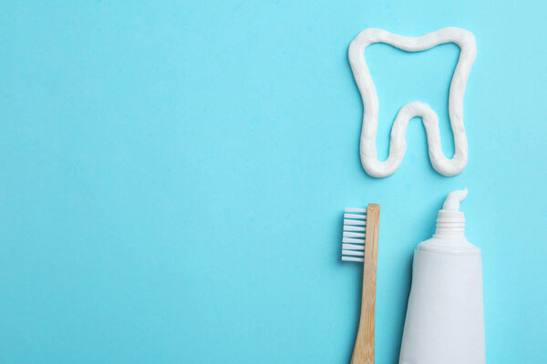 Tooth made of paste, tube, brush and space for text on color background, flat lay