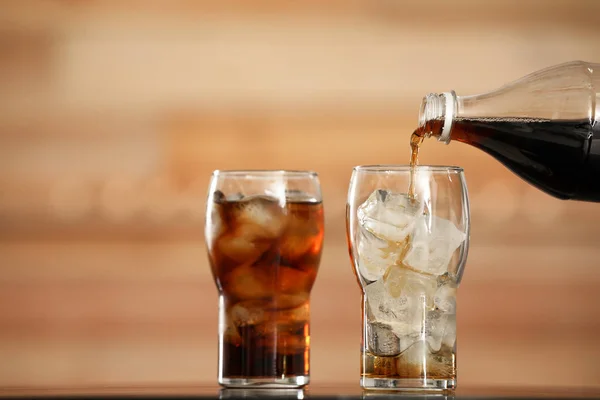 Pouring Cola Bottle Glass Ice Cubes Table Blurred Background — Stock fotografie