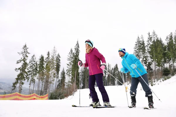 Joyeux Couple Avec Équipement Ski Assis Sur Une Colline Enneigée — Photo