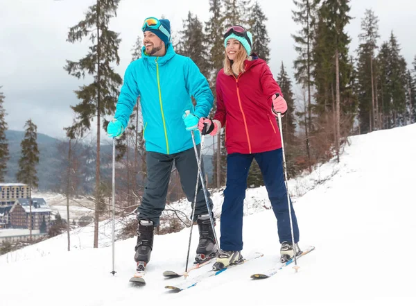 幸福的夫妇与滑雪设备坐在雪山雪山 文字的空间 — 图库照片