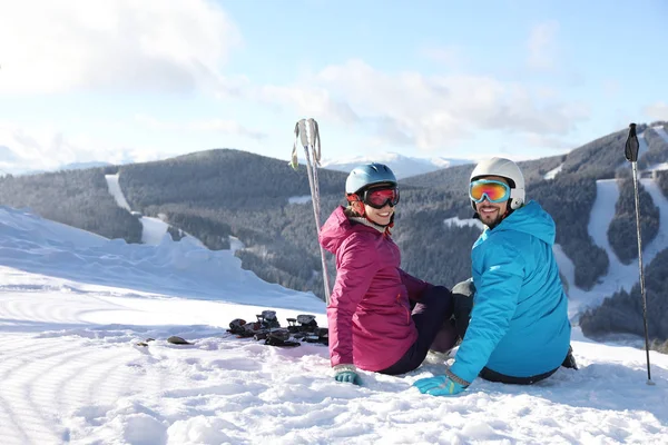 Pareja Feliz Con Equipo Esquí Sentado Colina Nevada Las Montañas —  Fotos de Stock