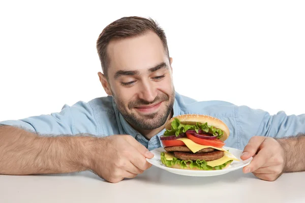 Joven Hombre Hambriento Con Sabrosa Hamburguesa Sobre Fondo Blanco —  Fotos de Stock