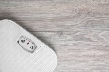 Scales on wooden background, top view with space for text. Weight loss clipart