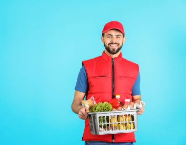 Renk arka plan, metin için yer üzerinde taze ürünlerle sepeti tutan adam. Gıda dağıtım hizmeti
