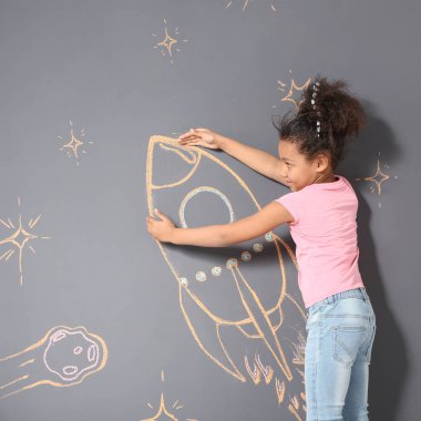 Tebeşir roket gri arka plan üzerinde çizim ile oynayan Afrikalı-Amerikalı çocuk