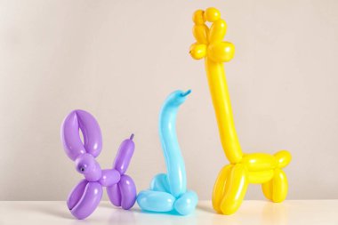 Balon renk arka plan karşı masada modelleme yapılmış hayvan figürleri
