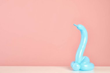 Balon renk arka plan karşı masada modelleme yapılan yılan figürü. Metin için yer