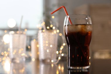 Bardak soğuk kola ve peri ışıkları masada. Metin için yer