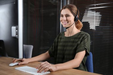 Kadın teknik destek operatörü ile kulaklık işyerinde