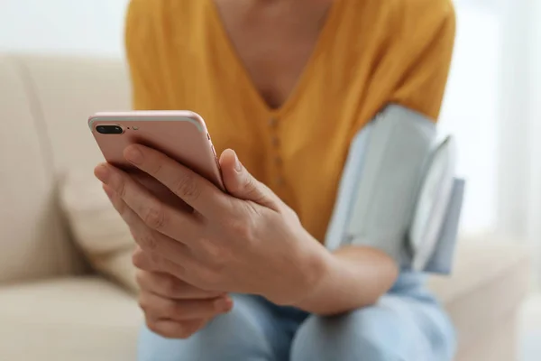 Mulher Verificando Pressão Arterial Com Monitor Moderno Smartphone Dentro Casa — Fotografia de Stock