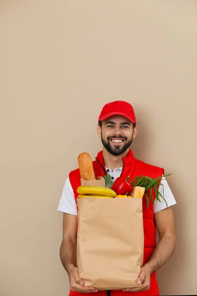 Mann Hält Papiertüte Mit Frischen Produkten Auf Farbigem Hintergrund Essenslieferdienst — Stockfoto