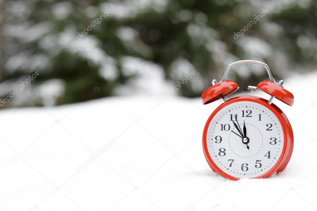 Red alarm clock on white snow outdoors. Space for text