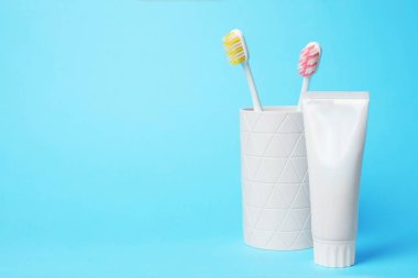 Fırçalar ve renk arka plan üzerinde diş macunu ile sahibi. Metin için yer