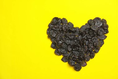 Kalp renk arka plan, metin için yer ile üstten görünüm üzerinde lezzetli Kuru Erik yığını şeklinde. Kurutulmuş meyve sağlıklı çerez olarak