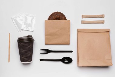 Kağıt poşet ve beyaz arka plan üzerinde farklı paket servisi olan restoran öğeleri düz yatıyordu kompozisyonu. Alan tasarımı için