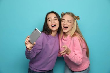 Genç kadın selfie renk arka plan karşı çekerken gülüyor