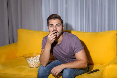 Patlamış mısır Tv oturma odasında kanepede ile izleyen duygusal adamım