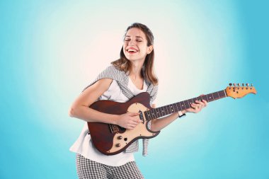 Genç kadın renk arka plan üzerinde elektro gitar çalmak