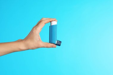 Kadın doktor astım inhaler renk arka plan, metin için yer görünümüyle portre üzerinde tutarak. Tıbbi nesne