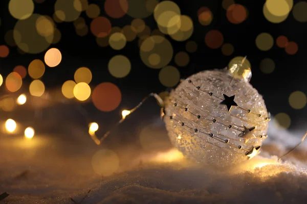 Weihnachtskugel Und Leuchtende Lichter Auf Schnee Vor Verschwommenem Hintergrund Platz — Stockfoto